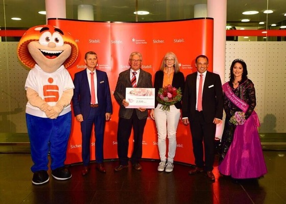 Mit Sparkassen-Maskottchen posieren Peter Schmat, Klaus Friedrich, Karin Menzel, Jens Gerards und Rosenkönigin Jacqueline I.